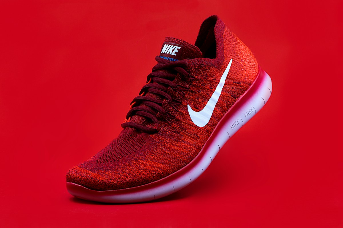Red athletic sneaker against a vivid red background